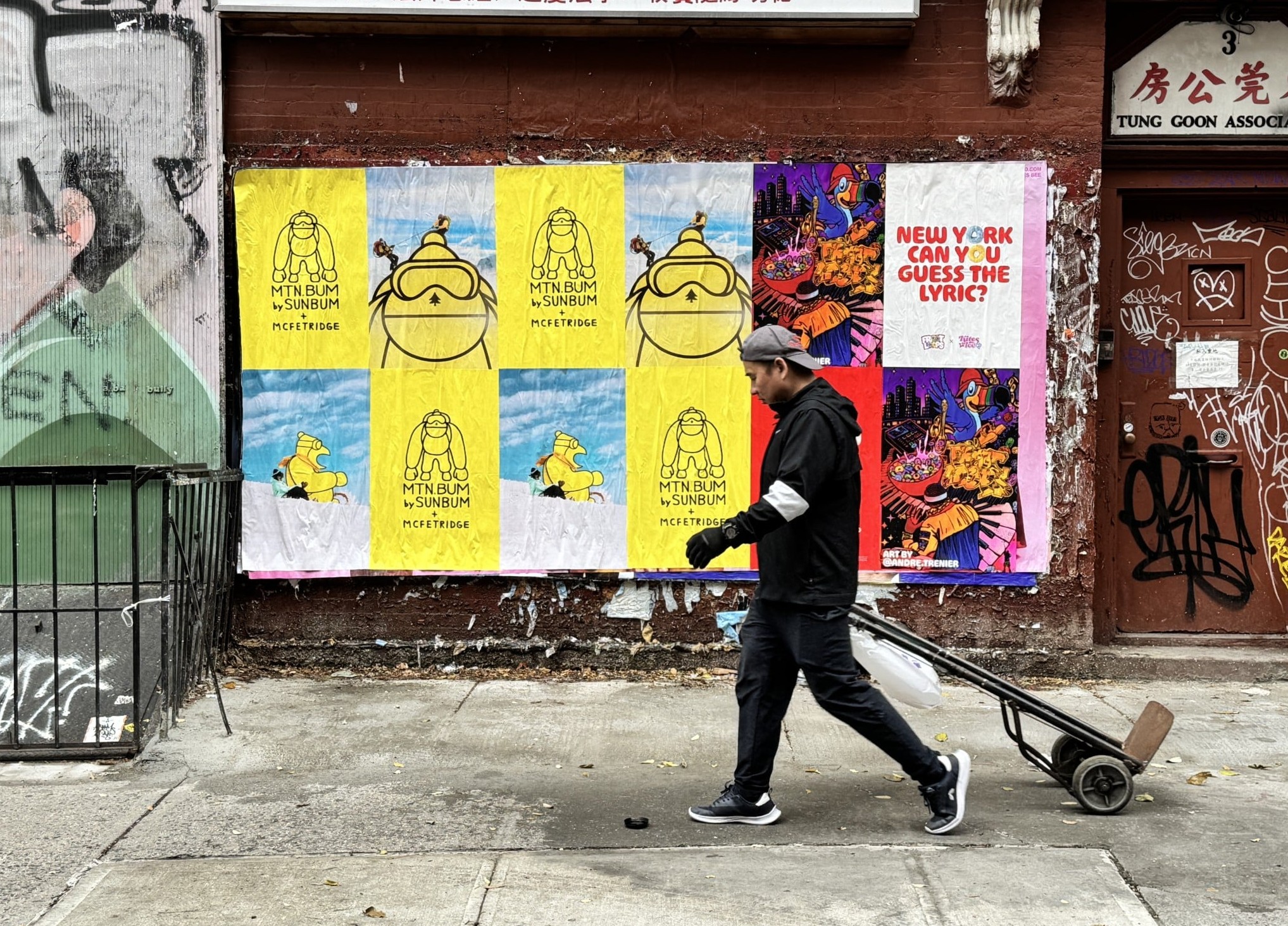 “Wild Posting® wall in New York City with MTN BUM × SUNBUM posters and colorful street art on a brick building.”