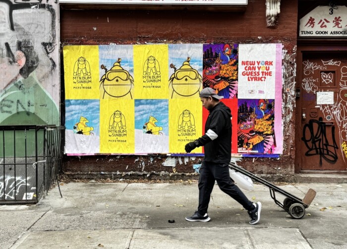 “Wild Posting® wall in New York City with MTN BUM × SUNBUM posters and colorful street art on a brick building.”