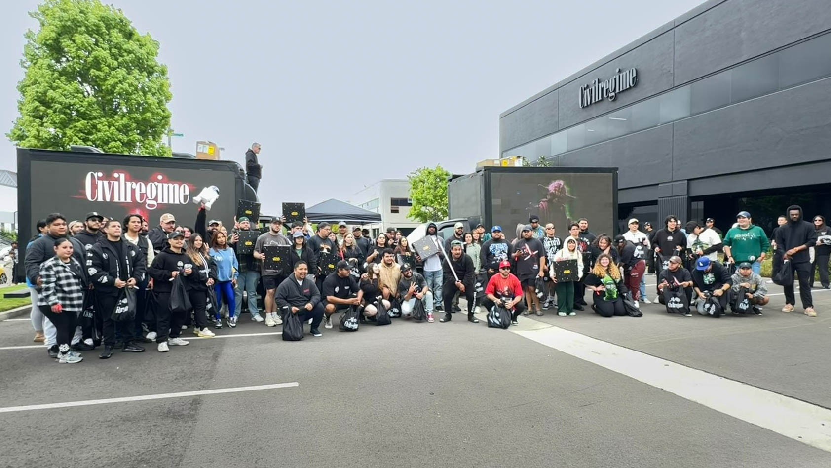 Large group of people gathered outside the Civil Regime building during a brand activation event with two digital mobile billboards displaying Civil Regime content.