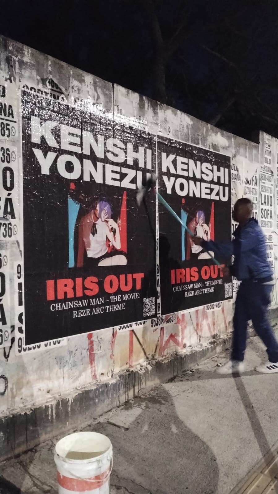 Kenshi Yonezu Wild Posting® campaign installed on a street-level wall in Miami at night