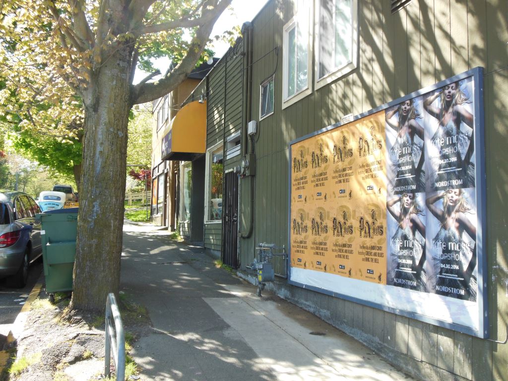 Pixies Wild Posting® music campaign posters installed along a neighborhood pedestrian street