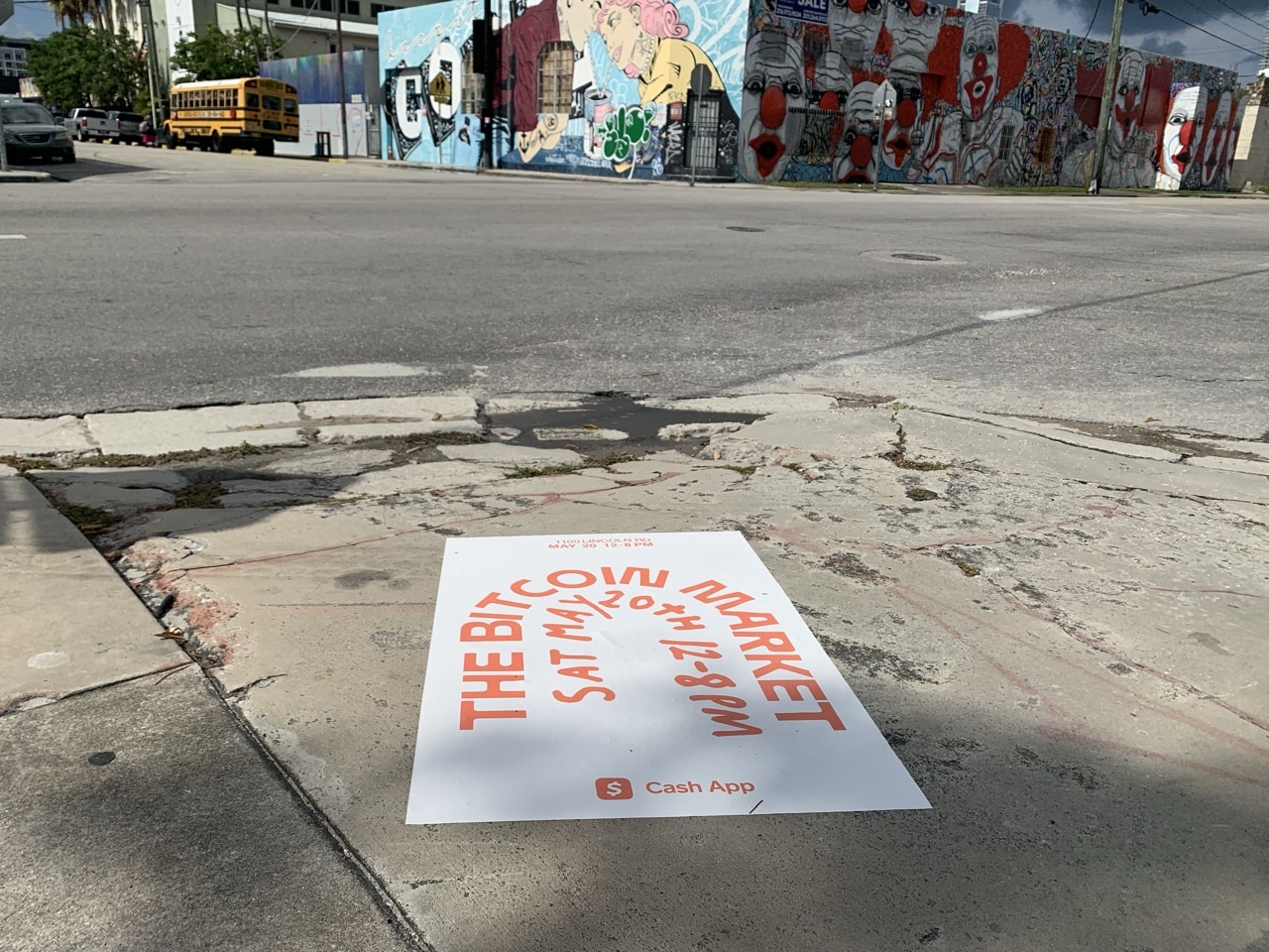 Cash App sidewalk decal promoting The Bitcoin Market event on May 20th, installed on a Miami sidewalk in Wynwood with street-art murals in the background.