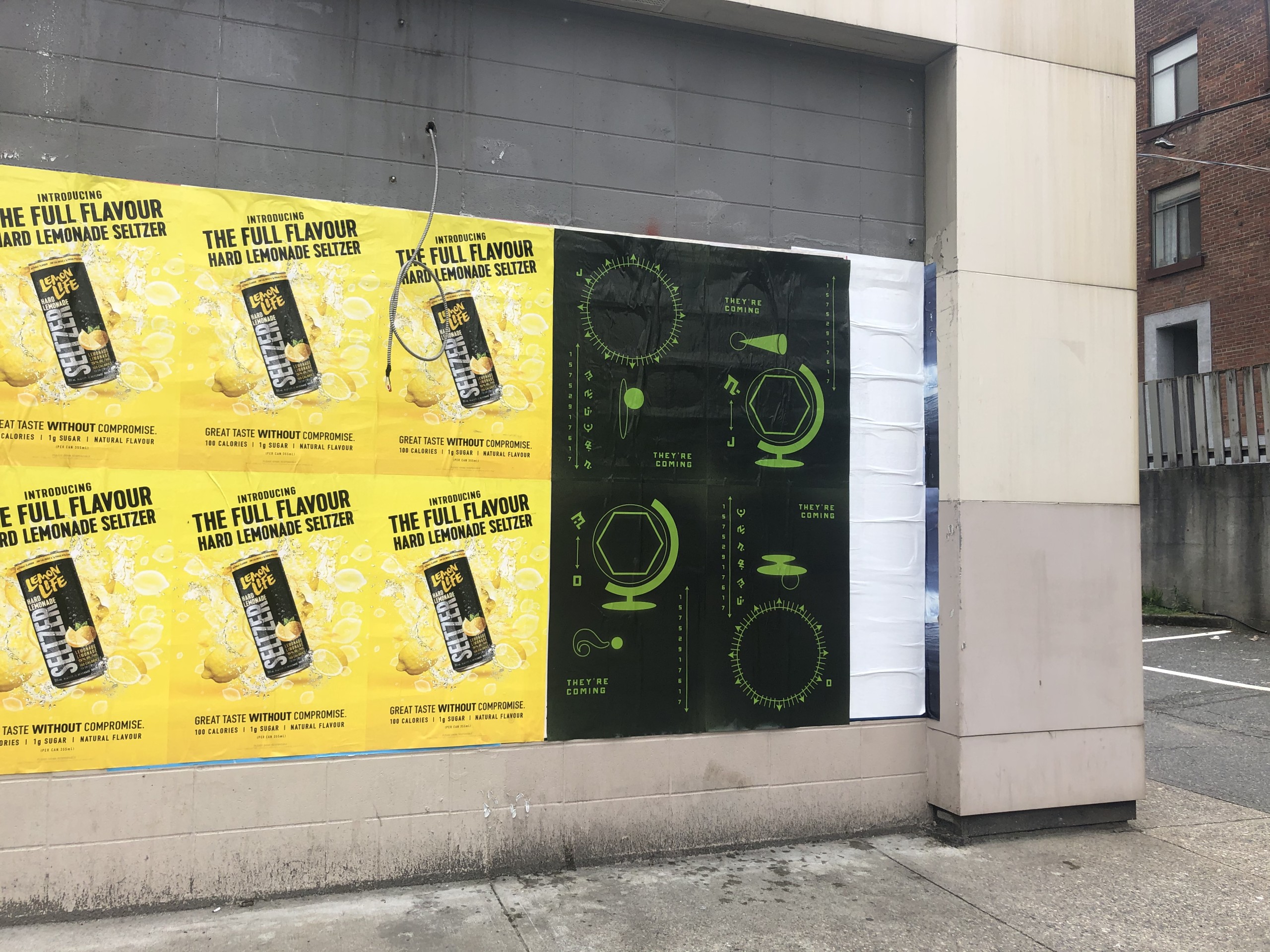 Wild Posting® street poster campaign in Vancouver featuring hard lemonade seltzer ads alongside Fortnite teaser graphics