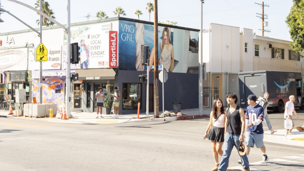 VRG GRL fashion billboard displayed at a busy street corner on Melrose Avenue in Los Angeles