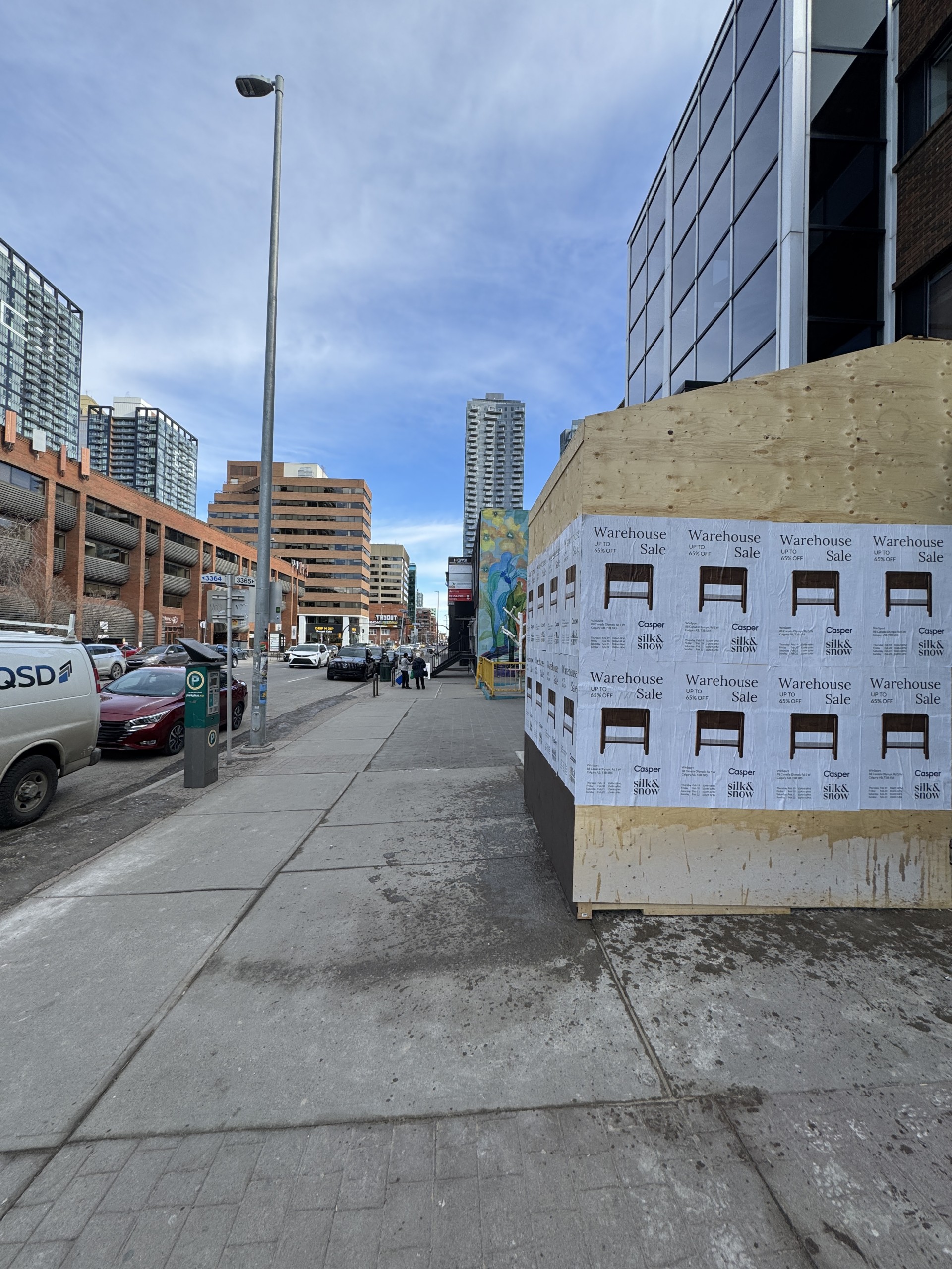 Wild Posting® campaign installed on construction plywood panels along a downtown street in Calgary, Alberta, Canada.