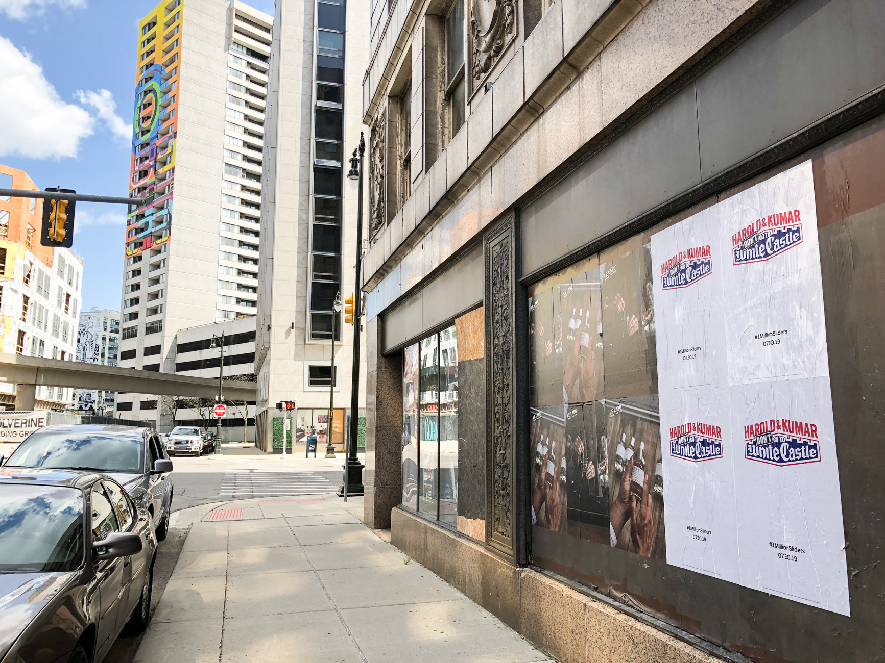 Wild Posting® campaign installed across storefront windows in Downtown Detroit, Michigan near high-rise office buildings.