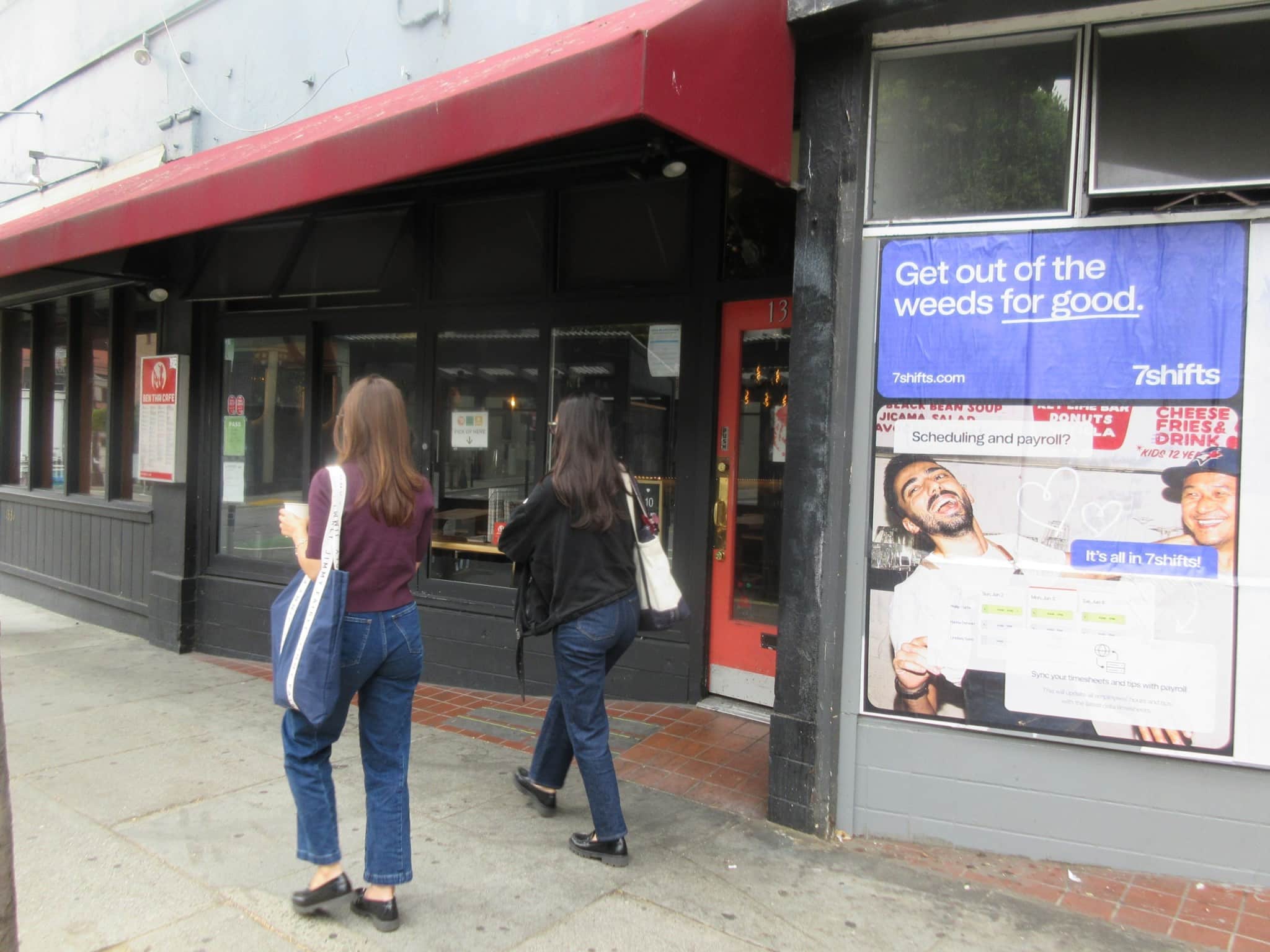 Wild Posting® window posters for 7shifts on a restaurant storefront at Polk St in San Francisco, with pedestrians walking by.